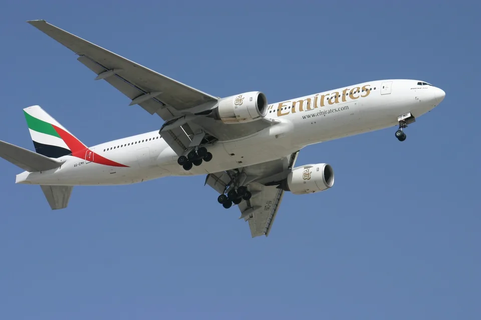 Emirates Boeing 777 A6-EMH in flight with its landing gear extended at Dubai