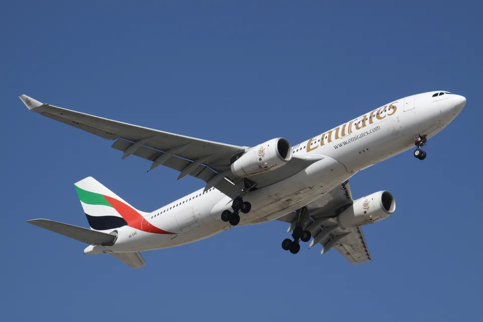 Emirates Airbus A330-243 A6-EAQ with landing gear extended at Dubai.