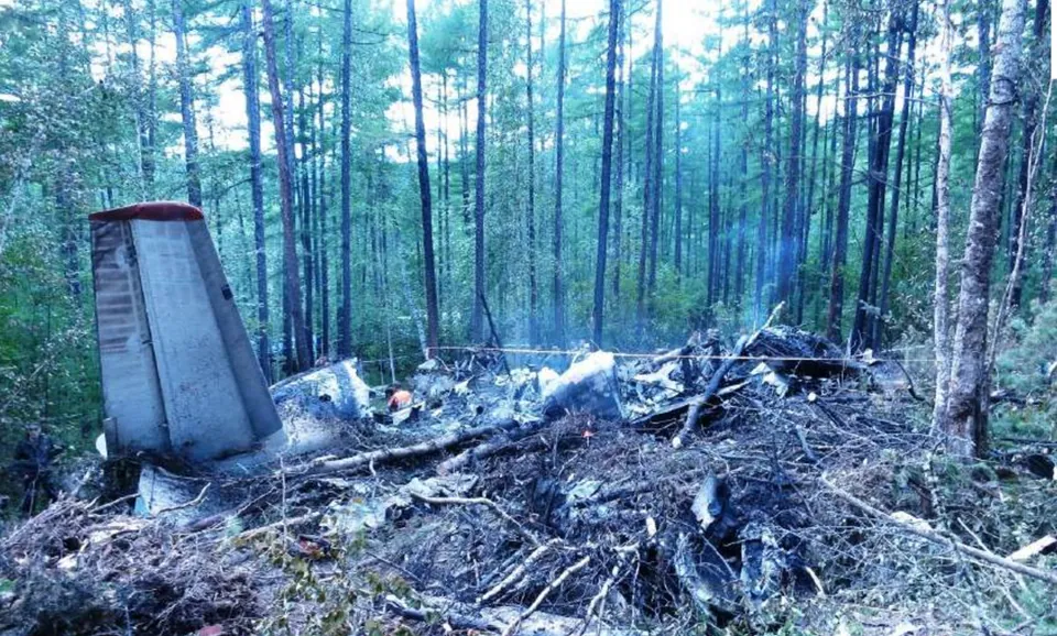 Main aircraft wreckage among trees at the accident site.