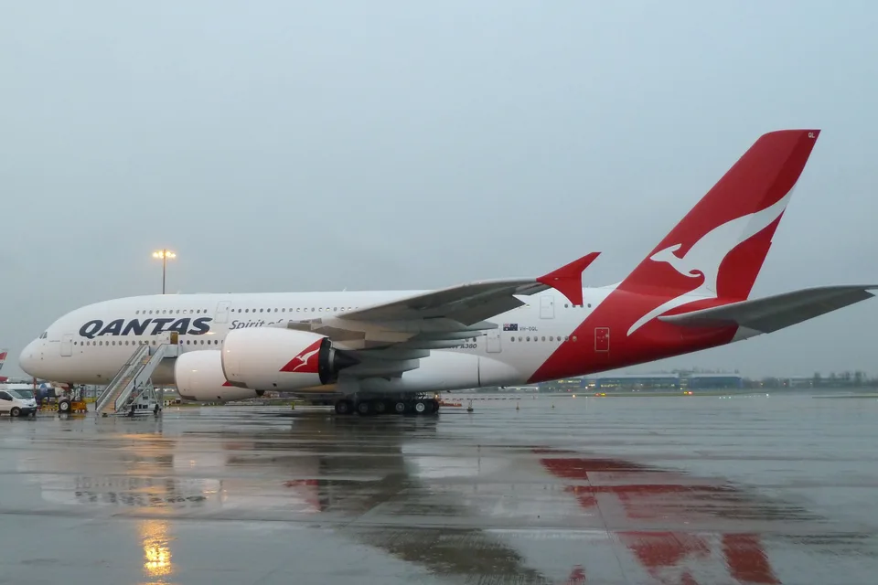 Qantas Airbus A380 VH-OQL parked at London Heathrow in wet weather.