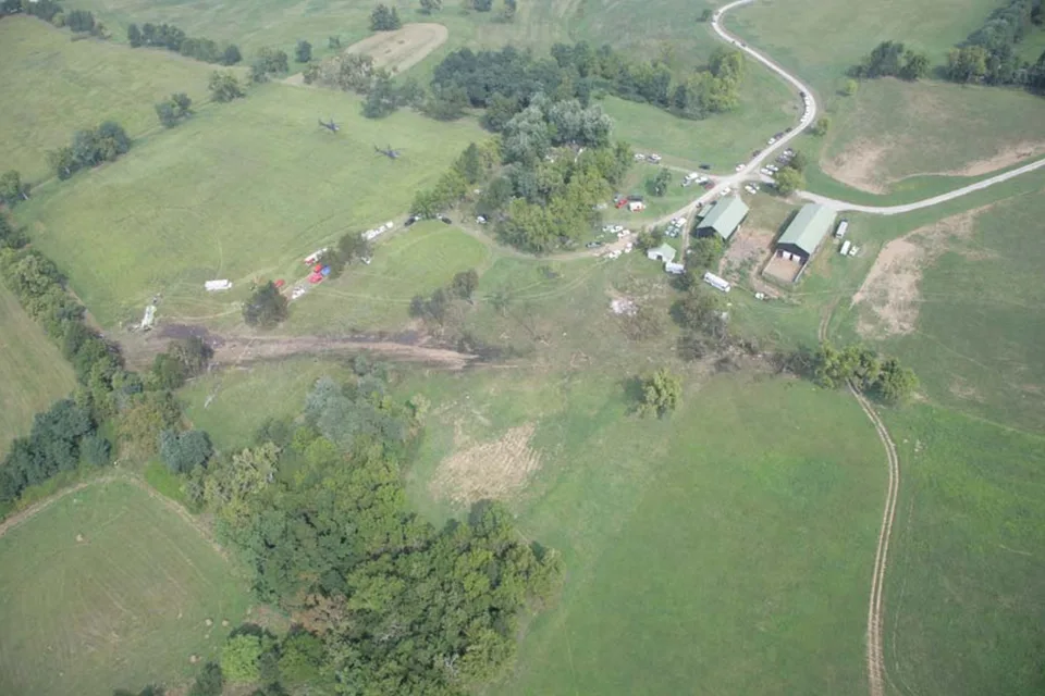 Aerial view of the Comair 5191 wreckage site, with ground scars across a field and damaged trees.