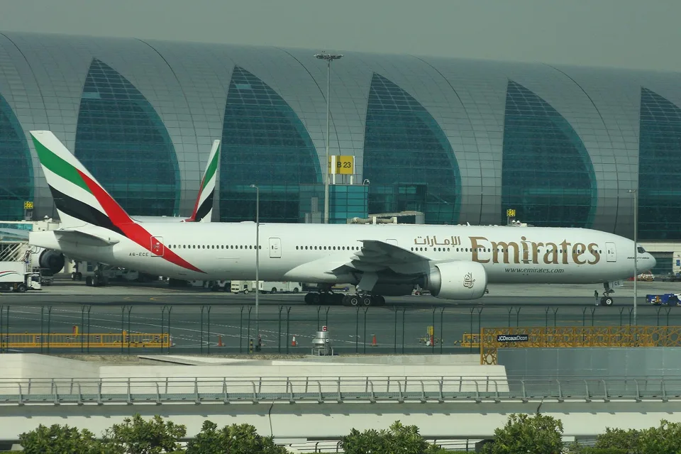 Emirates Boeing 777 A6-ECE parked outside a Dubai terminal.