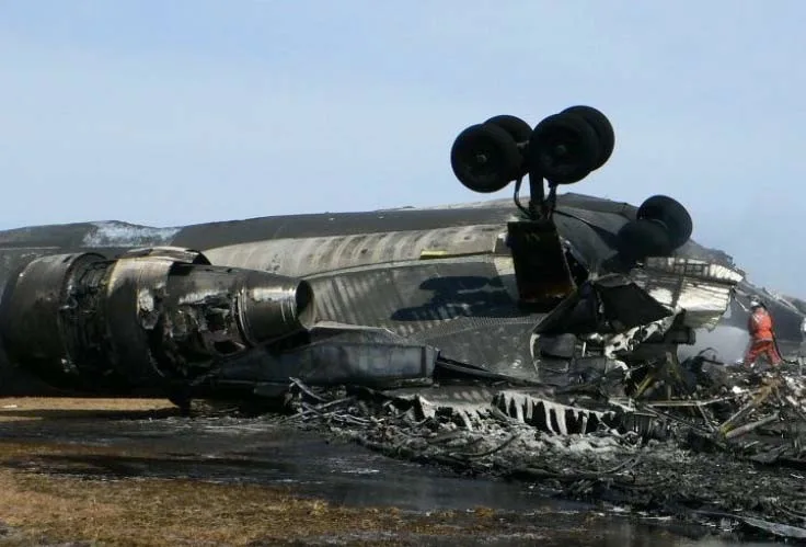 Burned inverted fuselage of FedEx 80 with landing gear above the wreckage at Narita.