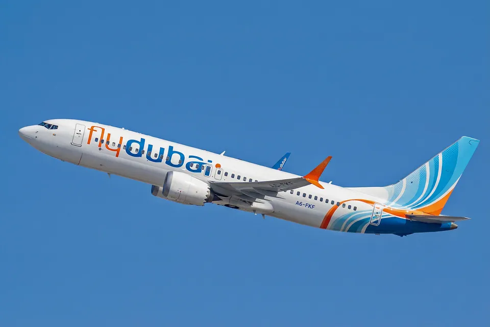Flydubai Boeing 737 MAX 8 A6-FKF airborne against a blue sky.