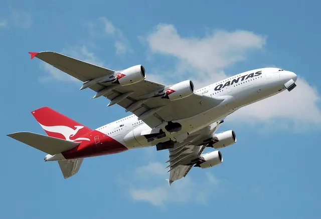 Qantas A380 VH-OQA climbing away from Heathrow, with four engines visible beneath its wings.