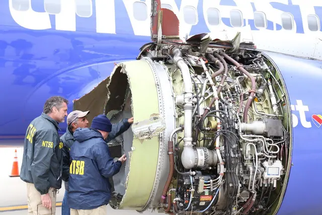 Two NTSB investigators examining Flight 1380's damaged left engine, with the engine's internal components exposed.