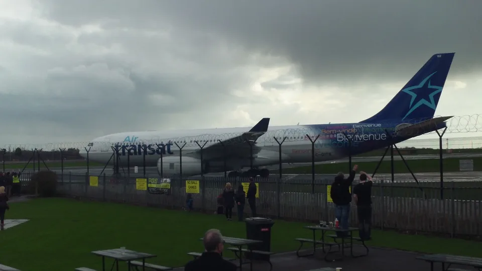 Air Transat Airbus A330 C-GITS beside an airport perimeter fence.