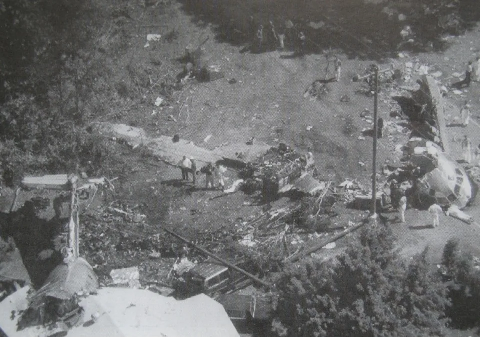 Aerial view of separated USAir Flight 1016 wreckage beside a road and house.